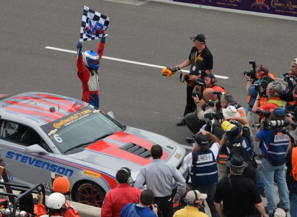 Robin Liddell waves the checkers and celebrates the Brickyard Grand Prix victory.  [Russ Lake Photo]