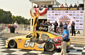 #54 Kyle Busch - - M&M Ice Cream (Toyota Supra) winner of 12th annual HENRY "180" Nascar Xfinity Series -Road America on 7/3/21. Kyle does a little celebrating on door of car. [Dave Jensen Photo]